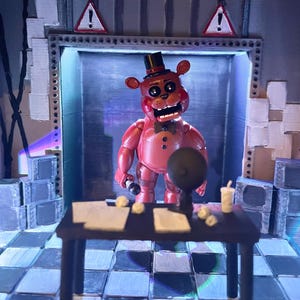 May include: A red bear-like figure wearing a black top hat and bowtie stands in a room with a chequered floor. A dark table in the foreground holds papers, a small globe, and a cup. Two triangular warning signs with exclamation marks are visible.