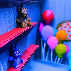 Puede incluir: Un diorama con una figura de oso marr&oacute;n y un conejito azul sobre estantes rojos. La escena incluye globos coloridos y un accesorio de pizza contra un fondo azul, creando una atm&oacute;sfera l&uacute;dica y caprichosa.