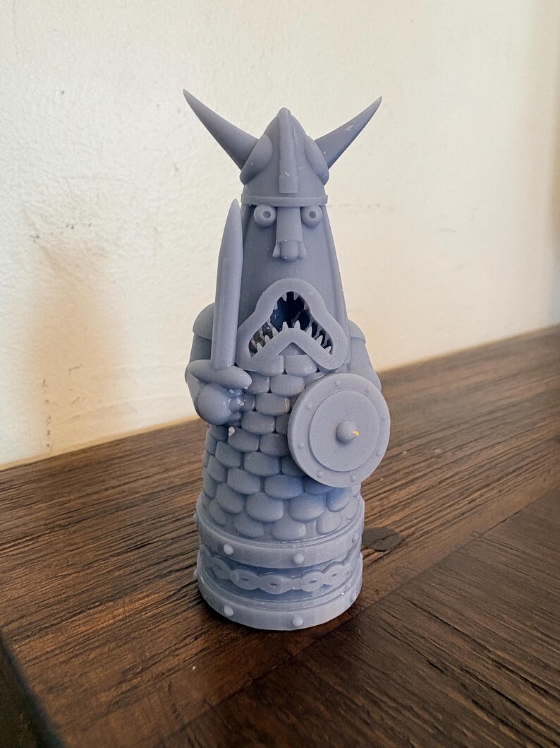 Op de afbeelding: Een lichtpaars 3D-geprint beeldje van een krijger met een gehoornde helm, die een zwaard in de rechterhand en een rond schild in de linkerhand houdt. Het figuur heeft een getextureerde, schubachtige romp, een wijd open mond en een voetstuk.