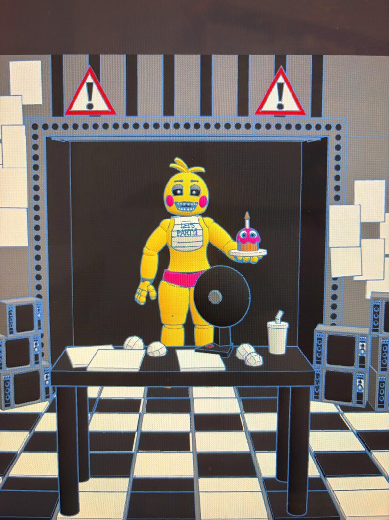 May include: A yellow animatronic chicken figure with pink cheeks and a white bib reading LET'S PARTY! holds a cupcake with a candle. The figure stands behind a black desk with papers, a fan, and a cup, set against a black and white checkered floor.