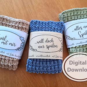 May include: Three knitted dishcloths with labels that say "Spül mit mir", "...will doch nur spülen", and "...alles nur Spülerei". The labels are all white with black text and a border of small hearts. The dishcloths are beige, blue, and green. The text "Digitaler Download" is written in a brown oval on the bottom right of the image.