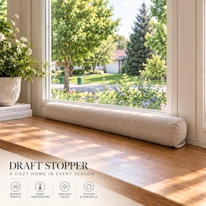 May include: A cylindrical beige fabric draft stopper positioned horizontally on a wooden windowsill. The text DRAFT STOPPER A COZY HOME IN EVERY SEASON is visible along with four icons labeled BLOCKS DRAFTS, KEEPS TEMPERATURE, REDUCES NOISE, and STYLISH & VERSATILE.