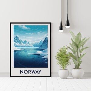 May include: A framed poster with a scenic view of a snow-capped mountain range and a body of water. The sky is blue with white clouds. The text "NORWAY" is printed in blue at the bottom of the poster.