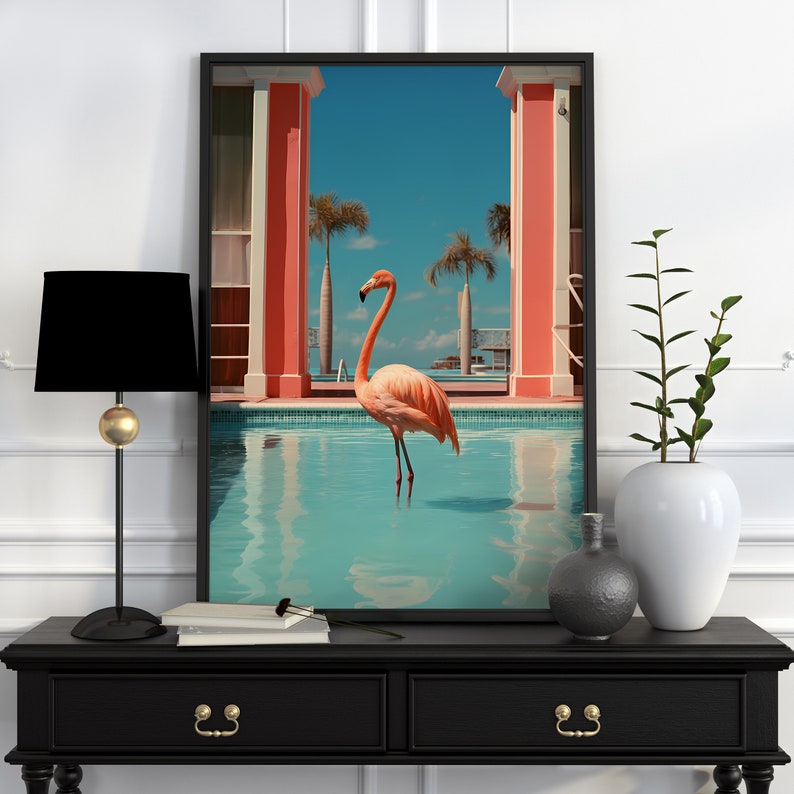 May include: A pink flamingo stands in a blue swimming pool with a pink and white building in the background. The image is framed in black.