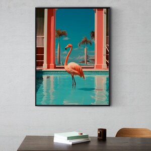May include: A framed print of a pink flamingo standing in a turquoise swimming pool. The pool is surrounded by a pink and white building with palm trees in the background.