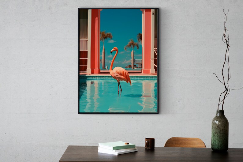 May include: A framed print of a pink flamingo standing in a turquoise swimming pool. The pool is surrounded by a pink and white building with palm trees in the background.