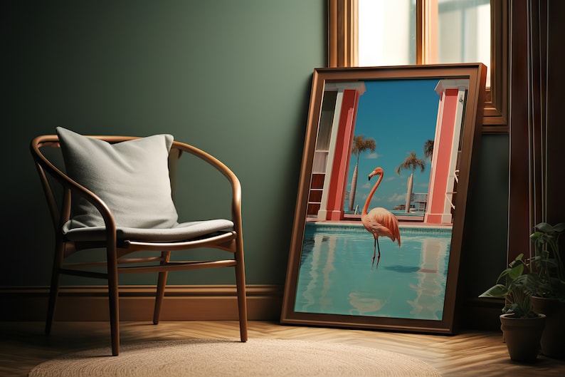 May include: A framed print of a pink flamingo standing in a pool of water. The pool is surrounded by red pillars and palm trees. The print is hanging on a wall in a room with a wooden chair and a green wall.