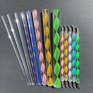 May include: A set of 15 nail art tools, including 10 clear acrylic sticks with different coloured swirl designs and 5 metal tools with different shaped tips. The tools are arranged in a row on a black surface.