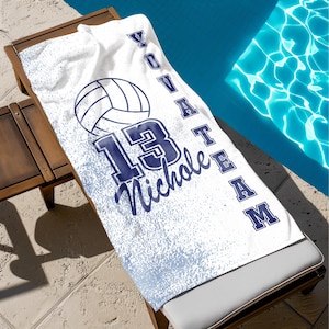 May include: White beach towel with a blue volleyball, the number 13, and the text "Volleyball Team" and "Nichole" in a blue script font.