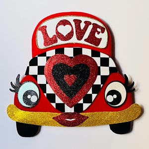 May include: Red, white, and black felt car with a checkered pattern and a large red heart with a smaller red heart inside. The car has a gold glitter trim and the word "LOVE" in red glitter letters on the top.