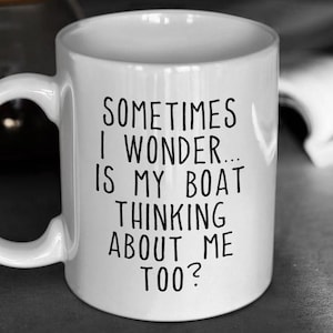 May include: White ceramic coffee mug with black text that reads "Sometimes I wonder... is my boat thinking about me too?"
