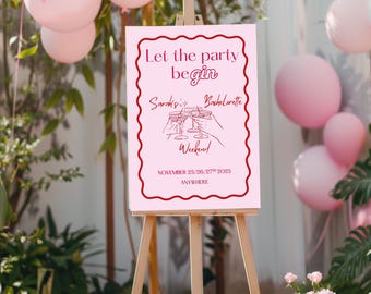 Könnte beinhalten: Ein rosa Schild auf einer hölzernen Staffelei mit dem Text "Let the party begin" und "Sarah's Bachelorette Weekend" in burgunderfarbener Schrift. Das Schild enthält eine Grafik von zwei anstoßenden Gläsern und das Datum.