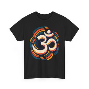 Könnte beinhalten: Ein schwarzes Kurzarm-T-Shirt mit einer zentralen Grafik des Om-Symbols. Das Symbol ist cremefarben mit dicken Umrandungen dargestellt und von konzentrischen, segmentierten kreisförmigen Ringen in den Farben Orange, Petrol und Dunkelblau umgeben.