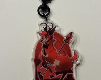Könnte beinhalten: Ein roter Hirsch mit Geweih und Fliege, der auf einem roten Hintergrund mit einem schwarzen Torbogen steht. Der Hirsch hält eine Lanze mit einem roten Edelstein oben. Das Bild ist auf einem durchsichtigen Acryl-Schlüsselanhänger mit einem schwarzen herzförmigen Verschluss gedruckt.