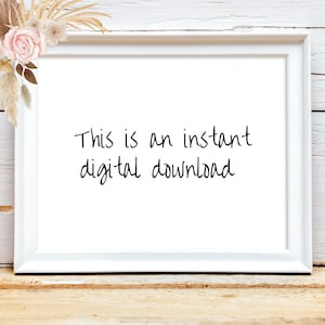 May include: A white framed print with the text "This is an instant digital download" in black script. The frame is on a wooden surface, with floral and dried plant accents in the upper left corner.