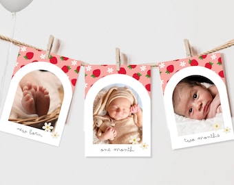 Puede incluir: Una pancarta de hitos para bebés de color rosa y blanco con fresas y flores. La pancarta tiene tres marcos de fotos con el texto "new born", "one month" y "two months".