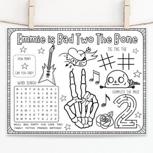 May include: Black and white printable colouring page with a word search, noughts and crosses game, maze, and a skeleton hand with the text "Emmie is Bad Two The Bone".