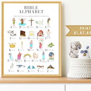 May include: A colorful alphabet chart with illustrations of Bible stories and characters. Each letter is paired with a corresponding Bible-related word, such as "A is for Adam" and "B is for Baptism". The chart is printed on a white background and framed in a light wood frame. The text "PRINT ON A1, A2, A3 OR A4" is visible at the bottom right corner of the chart.