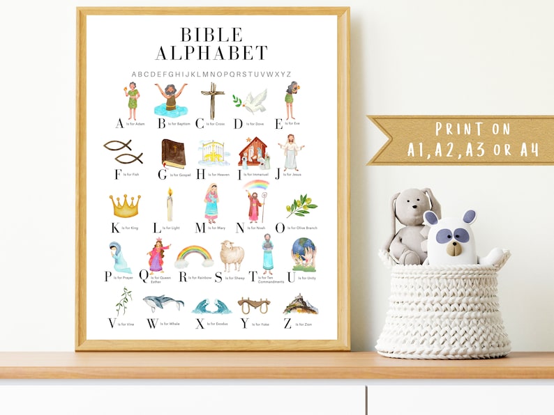 May include: A colorful alphabet chart with illustrations of Bible stories and characters. Each letter is paired with a corresponding Bible-related word, such as "A is for Adam" and "B is for Baptism". The chart is printed on a white background and framed in a light wood frame. The text "PRINT ON A1, A2, A3 OR A4" is visible at the bottom right corner of the chart.