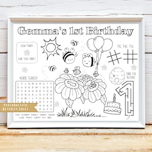 May include: A black and white printable activity sheet for a 1st birthday party. The sheet features a word search, a noughts and crosses game, a find the beehive maze, and a count the bees activity. The sheet also includes a birthday cake with a candle and the number 1 on it.