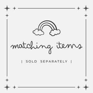 K&ouml;nnte beinhalten: Cremefarbene Grafik mit schwarzem Rahmen und Sternakzenten. Das Bild zeigt eine schwarze Regenbogen-Illustration &uuml;ber den Worten "matching items" in einer handschriftlichen Schriftart. Darunter steht "| SOLD SEPARATELY |".