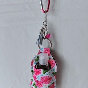Porta loción o desinfectante de manos con botellas vacías y adornos coloridos en un mosquetón para bolso, cartera o llavero. Múltiples estilos.