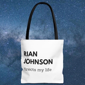 May include: White tote bag with black handles and the text "RIAN JOHNSON directs my life" printed on the front.