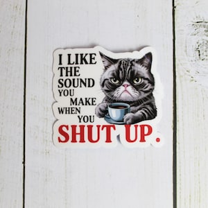 May include: A white sticker with a grumpy cat holding a cup of coffee. The text on the sticker reads "I like the sound you make when you shut up."