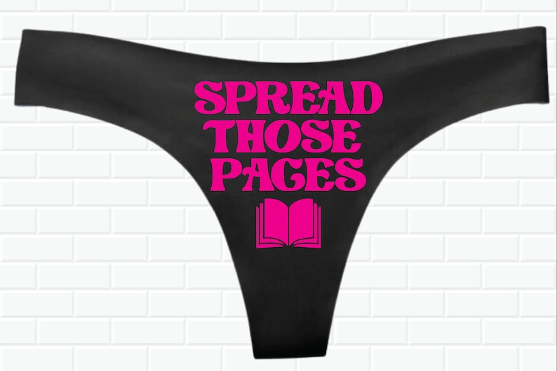 May include: Black underwear with a pink graphic that says "Spread Those Pages" and a pink book illustration.