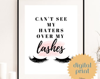 以下が含まれることがあります： 白い背景に黒い文字で「Can't see my haters over my lashes」と書かれたデジタルプリント。テキストはピンクの水彩のぼかしと黒いまつげのペアの上にあります。プリントには、黒い文字で「digital print」と書かれた金色の星形のステッカーが付いています。