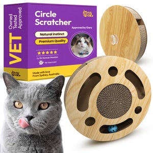Könnte beinhalten: Ein Kratzspielzeug für Katzen mit Holzrahmen und Karton-Kratzfläche. Das Spielzeug hat ein kreisförmiges Design mit einer Kugel im Inneren. Die Verpackung trägt die Aufschrift "Circle Scratcher" und "Natural Instinct". Eine graue Katze ist im Vordergrund.