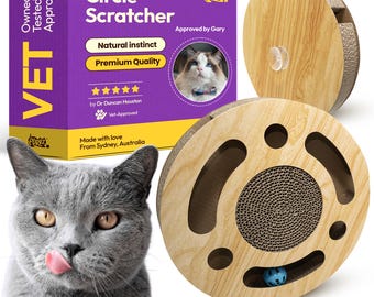 Puede incluir: Un rascador para gatos con marco de madera y superficie rascadora de cartón. El juguete tiene un diseño circular con una bola en el interior. El embalaje dice "Circle Scratcher" y "Natural Instinct". Un gato gris está en primer plano.