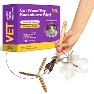May include: A cat wand toy with a wooden handle and a black wire. The toy features a Kookaburra bird design with brown and white feathers. The packaging is purple and yellow, with the text "Cat Wand Toy Kookaburra Bird".