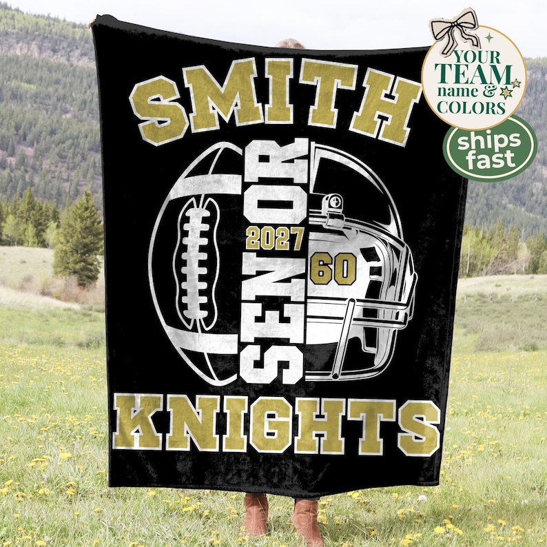 May include: A black fleece blanket featuring a large white and gold graphic of a football and a helmet. The text reads SMITH, SENIOR, 2027, 60, and KNIGHTS in bold block lettering. The design is centred on the fabric with high-contrast colours.
