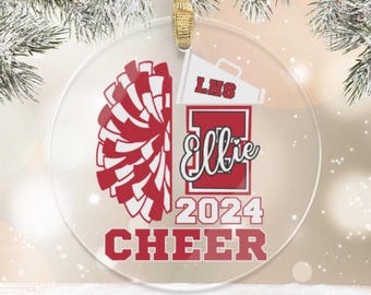 May include: A clear round Christmas ornament with a red and white pom-pom, a red megaphone with the text "LHS", a red letter "E" with the text "Ellie" and the text "2024 CHEER".