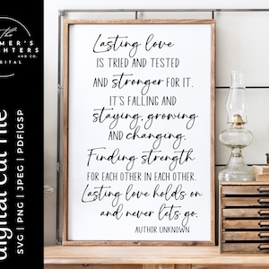 May include: A white sign with black text that reads "Lasting love is tried and tested and stronger for it. It's falling and staying, growing and changing. Finding strength for each other in each other. Lasting love holds on and never lets go. Author Unknown."