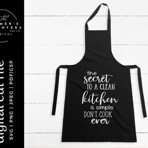 May include: Black apron with white text that reads "the secret to a clean kitchen is simple. DON'T COOK ever." The apron has a neck loop and waist ties. The left side of the image has the text "digital cut file".