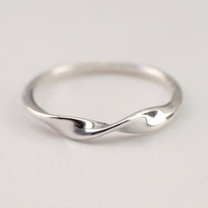 May include: A silver twisted band ring with a smooth, polished finish.