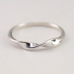 May include: A silver twisted band ring with a smooth, polished finish.