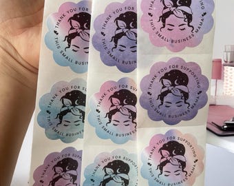 May include: Roll of round stickers with a watercolor design. The stickers feature a woman with a bun and a headband, a crescent moon, and stars. The text on the stickers reads "Thank you for supporting this small business mama".