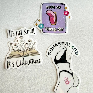May include: A collection of four stickers with various designs. One sticker reads "It's not Smut". Another shows an open book with flowers and the text "It's Cliterature". A third sticker has a switch with the text "Book: On World: Off". The last sticker is a silhouette of a person in a bikini.
