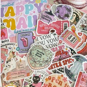 May include: A collection of colorful stickers with various designs and text, including "Happy Mail," "Spicy Book Club," and "Open to Book Recs." The stickers feature floral and book-related themes, with a pastel color palette.