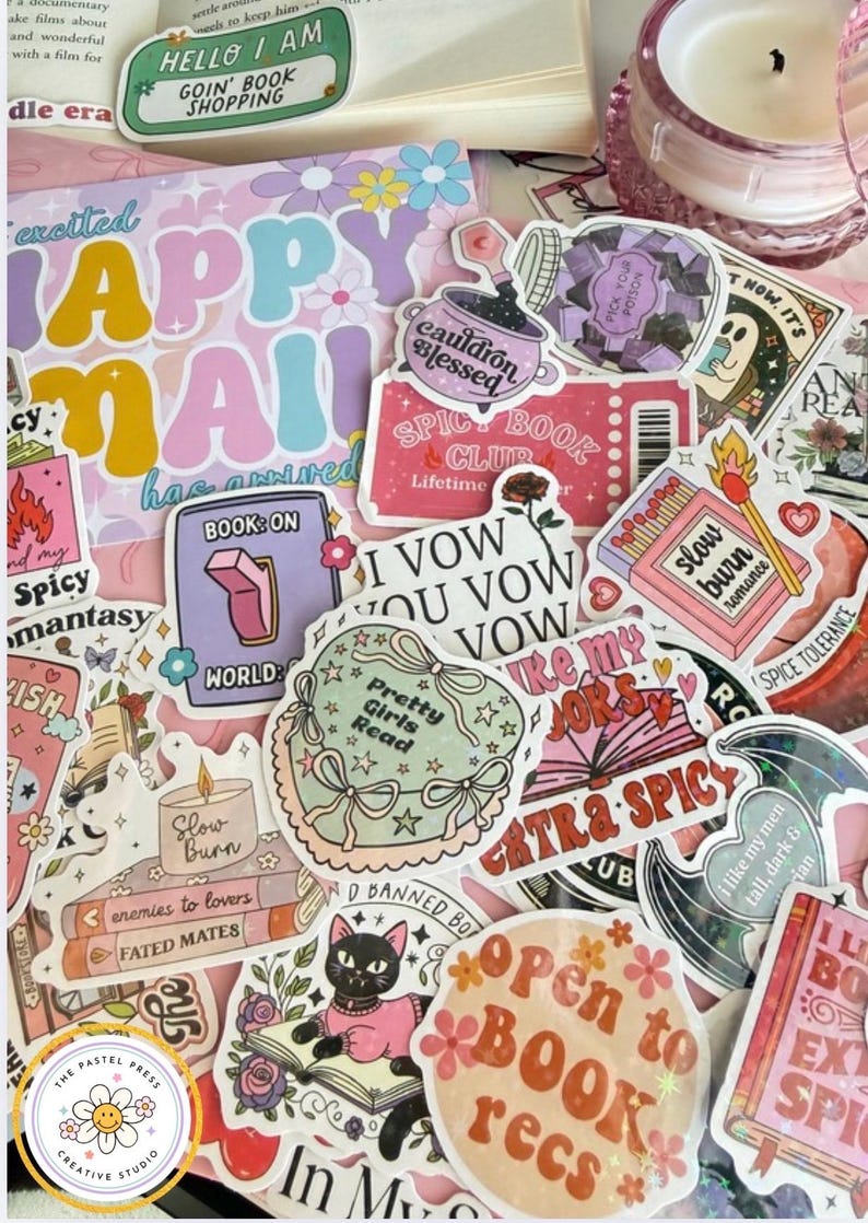 May include: A collection of colorful stickers with various designs and text, including "Happy Mail," "Spicy Book Club," and "Open to Book Recs." The stickers feature floral and book-related themes, with a pastel color palette.