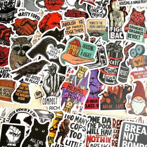 Puede incluir: Una colección de pegatinas de vinilo variadas con diversos temas políticos y sociales, incluyendo ilustraciones de animales, cartas de juego y eslóganes de texto audaces como Abolish Prisons, Housing is a Right y No Kings Power to the People.