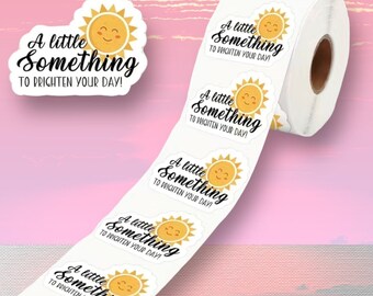 May include: A roll of white stickers with a smiling sun graphic and the text "A little Something to Brighten Your Day!". The stickers are oval-shaped with a yellow sun and black text.