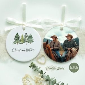 May include: Two white, round Christmas ornaments with cream-colored ribbon. One features a watercolor forest scene and the words "Custom Text." The other displays a photo of a couple riding horses. The words "Double Side" are also visible.