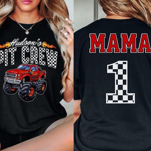Pu&ograve; includere: Due magliette nere a tema corse. Una maglietta dice "Hudson's Pit Crew" con una grafica di un monster truck rosso. L'altra maglietta dice "MAMA" con una bandiera a scacchi numero uno.