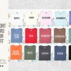 May include: A color chart displaying a variety of Comfort Colors t-shirts. The shirts are arranged in rows and columns, showcasing colors like white, ivory, blossom, chambray, and flo blue. The chart includes the text "Comfort Colors Color Chart" and the Shop of Paradise logo.