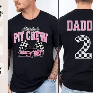 May include: Two black t-shirts with pink text. One shirt says "Madelyn's Pit Crew" with a pink race car and checkered flags. The other shirt says "Daddy" with a pink number "2" with a checkered pattern.