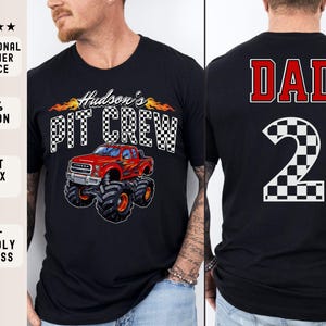 Pu&ograve; includere: Due magliette nere con un design di monster truck e il testo "Hudson's Pit Crew" su una maglietta e il testo "DAD" e un numero a scacchi "2" sull'altra maglietta.